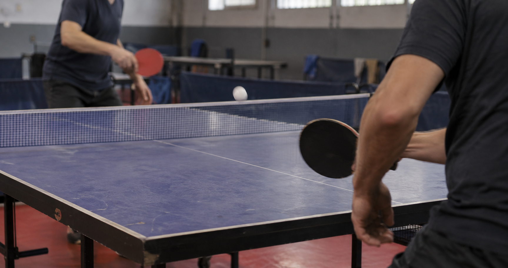 Mains d’un joueur de tennis de table avec sa raquette